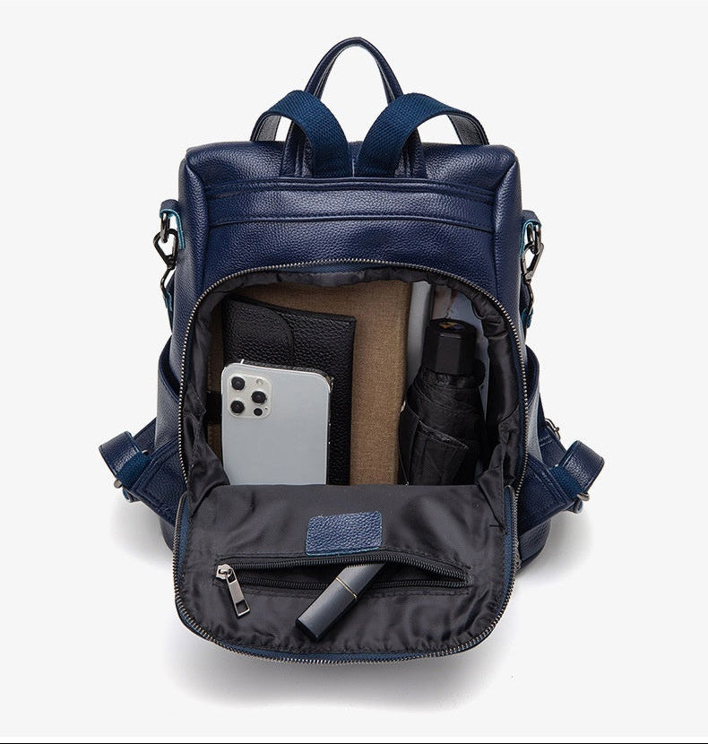 Blue backpack with compartments and items displayed on a white background